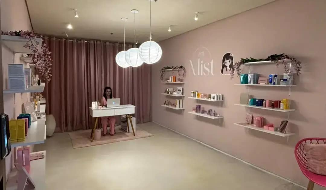 Interior da Mist Cosméticos, com prateleiras de produtos cosméticos para cuidados com a pele e os cabelos, decoração em tons de rosa e balcão de atendimento