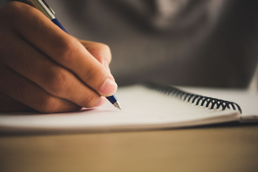 Man hand with pen writing on notebook