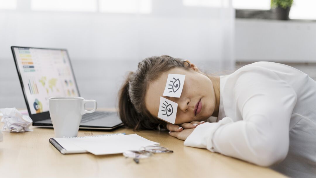 mulher de negocios cansada cobrindo os olhos com olhos desenhados no papel