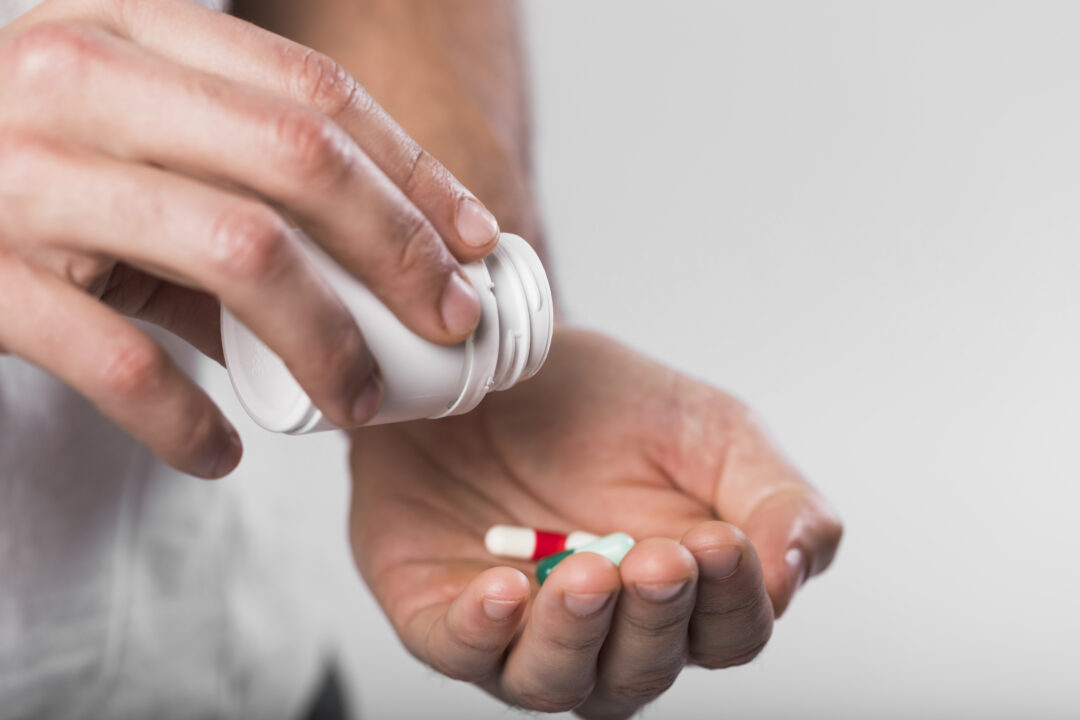 close up maos segurando capsulas medicas