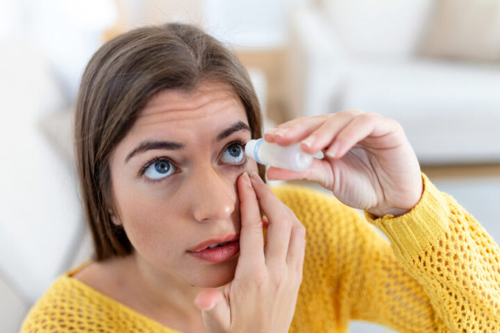 Ar seco cuidado com os olhos Mulher usando colírio
