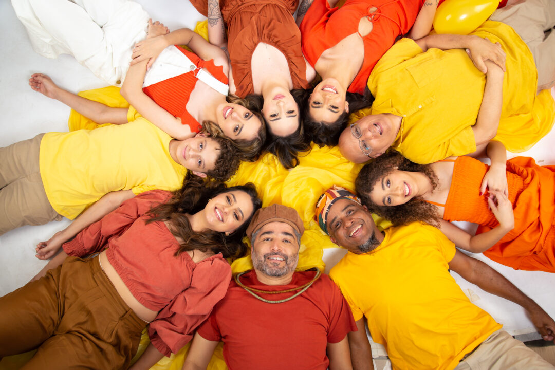 Integrantes do grupo Pé de Sonho posam em círculo com roupas coloridas para divulgação do show no Palácio das Artes, em Belo Horizonte.