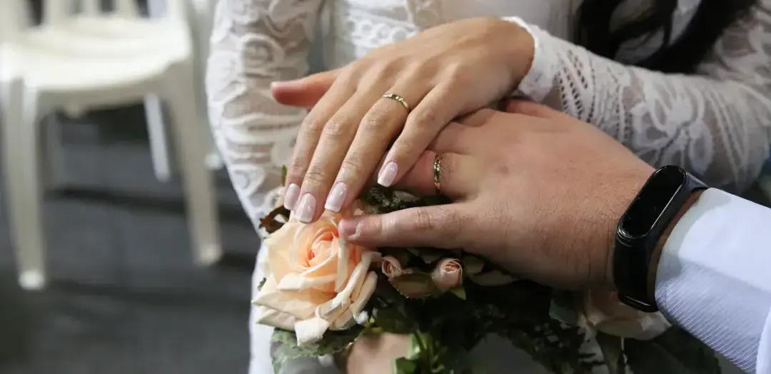 Casal com alianças nas mãos durante cerimônia de casamento civil em Belo Horizonte