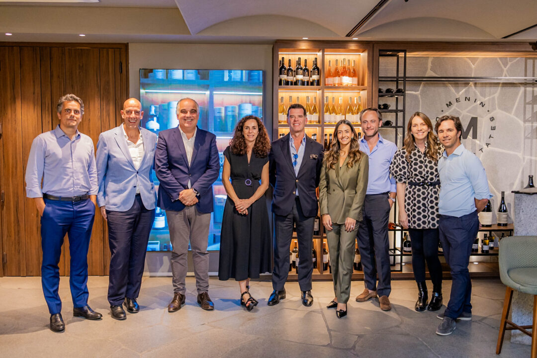 Grupo de executivos reunidos no Espaço Altíssimo, no Meeting Shops, durante encontro promovido por Inter e Avenida sobre investimentos offshore, com painel de vinhos ao fundo