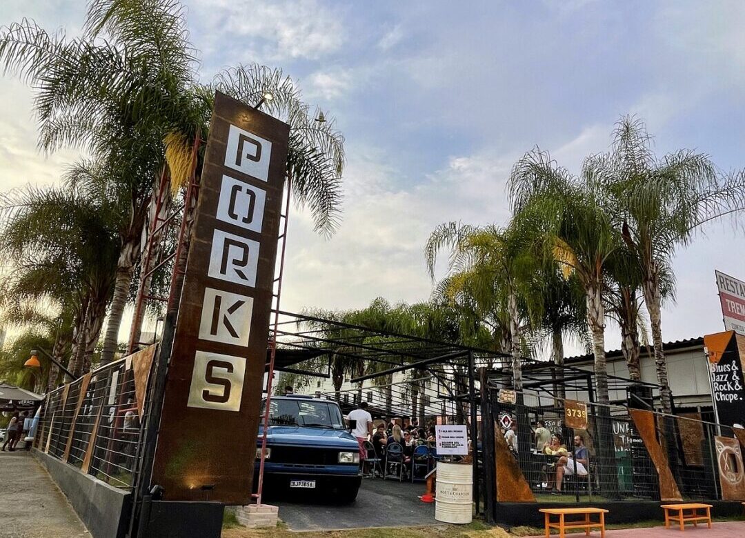 Entrada do Porks Castelo em Belo Horizonte com público reunido na área externa do bar durante evento com automóveis clássicos