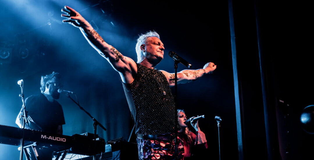 Andy Bell, vocalista do Erasure, se apresenta em show solo em palco iluminado durante apresentação ao vivo
