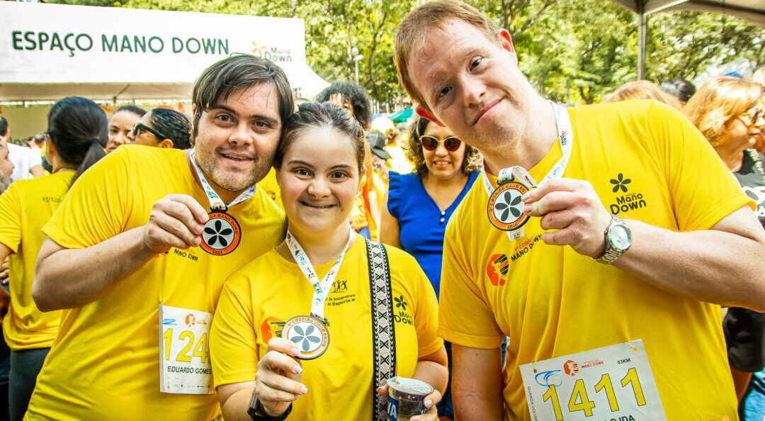 Participantes da Corrida Mano Down exibem medalhas durante evento de inclusão e conscientização da síndrome de Down na Pampulha, em Belo Horizonte