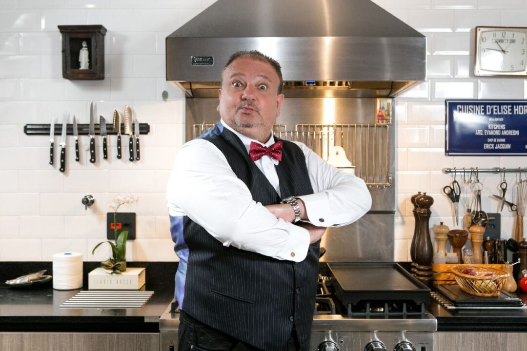 Renomado Chef francês, Erick Jacquin em cozinha gastronômica com utensílios ao fundo