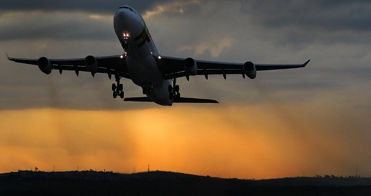 Avião decolando no BH Airport ao entardecer, terminal mineiro entre os 10 aeroportos mais pontuais do mundo segundo ranking internacional