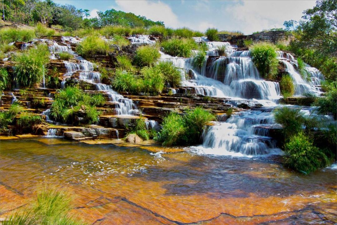 Cachoeira em Capitólio, Minas Gerais, com águas cristalinas e vegetação ao redor é destaque do guia de destinos da Kayak