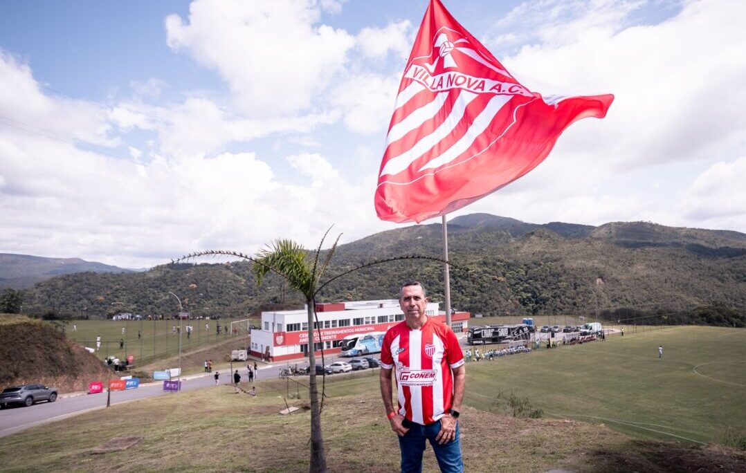 Bandeira do Villa Nova no Centro de Treinamento Anísio Clemente, em Nova Lima, com campos e estrutura ao fundo