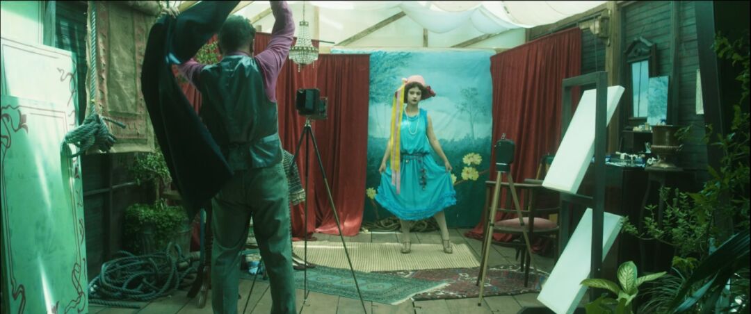 Cena do documentário O Silêncio de Eva mostra personagem em estúdio fotográfico recriando o universo do cinema mudo brasileiro