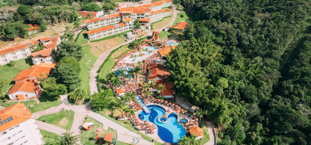 Vista aérea do Tauá Resort Caeté com piscinas, área de lazer e estrutura cercada por natureza durante programação de Páscoa