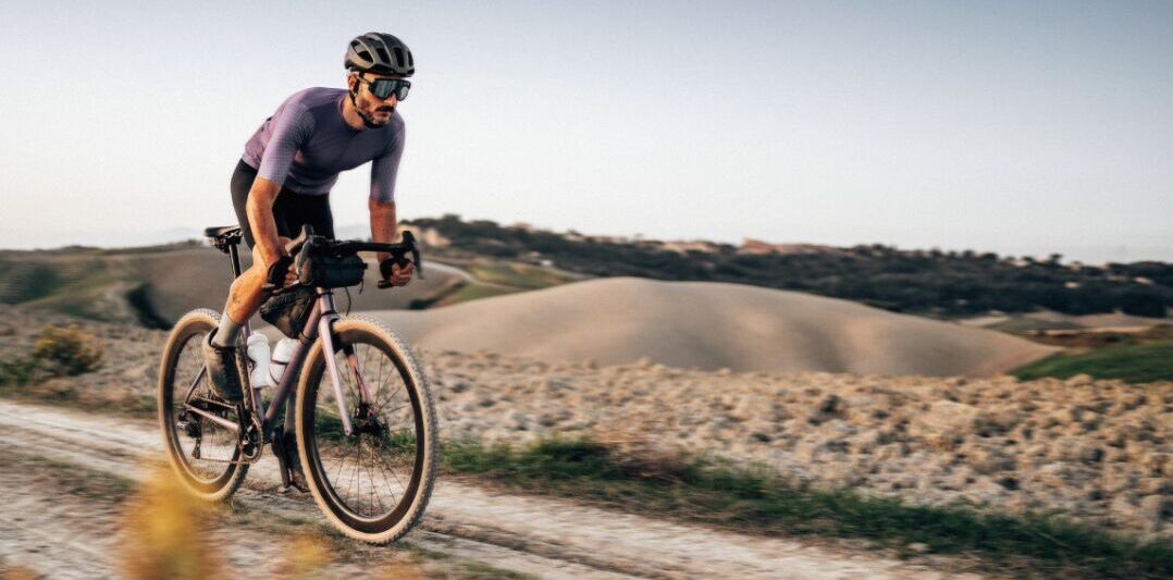 Atleta de ciclismo durante treino ao ar livre, imagem que representa saúde, exercício e performance esportiva debatidos no simpósio da Rede Mater Dei de Saúde