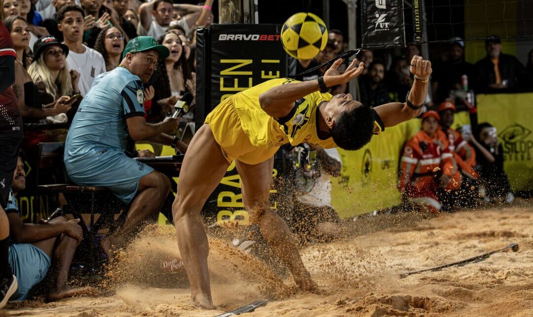Atleta executa jogada de ataque durante etapa do campeonato nacional de futevôlei Brasil Open em arena de areia com público ao fundo em Nova Lima