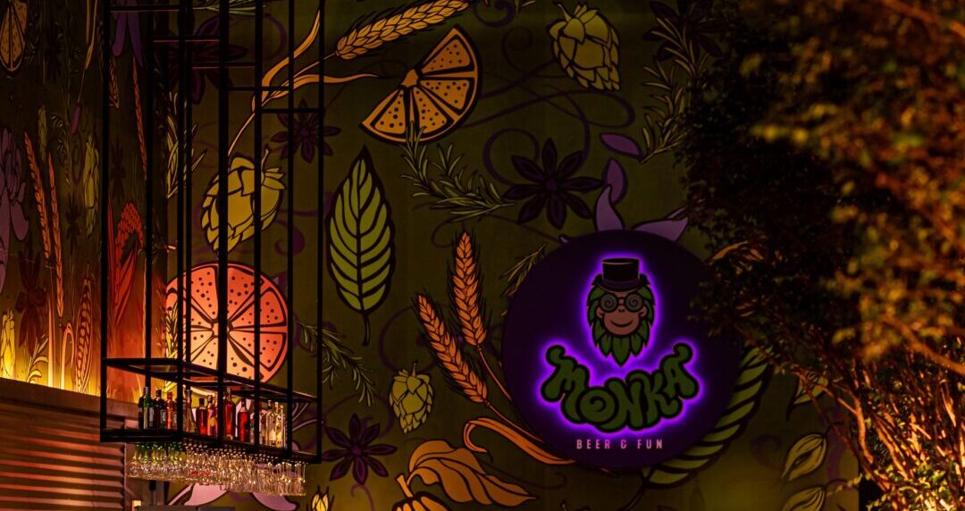 Ambiente interno da Cervejaria Monka decorado com iluminação e bar durante evento temático