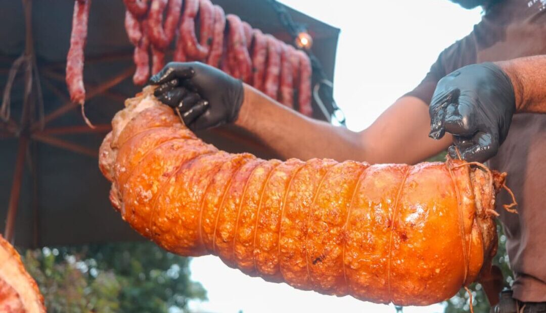 Carne suína sendo preparada em espeto durante festival gastronômico no Barro Preto, em Belo Horizonte