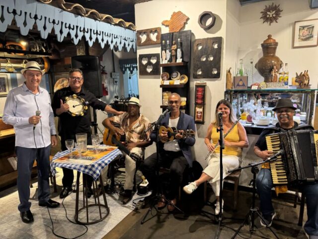 Luiz antonio e banda apresentação musical integra programação do Festival Santa Seresta em Santa Tereza Luiz Antônio e banda se apresentam com instrumentos como violão, cavaquinho e acordeão durante seresta em ambiente interno no bairro Santa Tereza