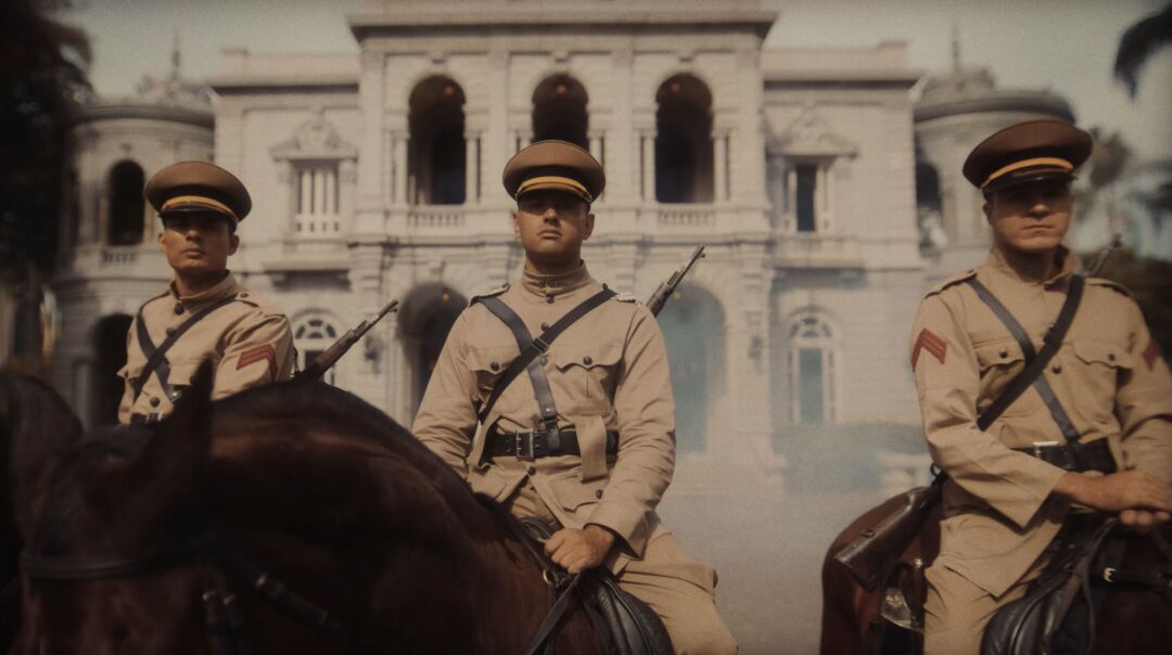 Cena do filme comemorativo dos 250 anos da Polícia Militar de Minas Gerais mostra policiais montados a cavalo em frente a prédio histórico durante reconstituição de período histórico