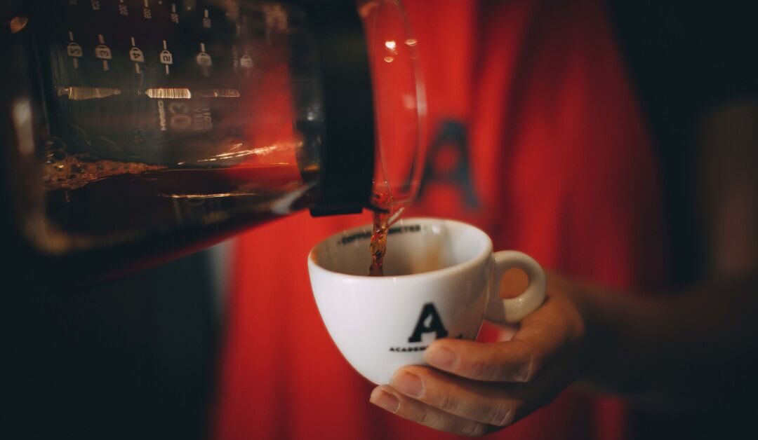 Café sendo servido em xícara da Academia do Café durante experiência imersiva sobre cafés especiais em Belo Horizonte