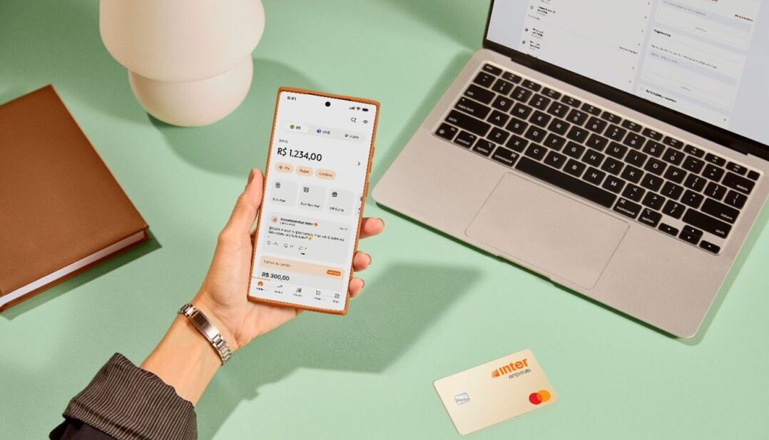 Aplicativo do Inter Empresas em smartphone ao lado de notebook durante operação financeira para pequenas e médias empresas