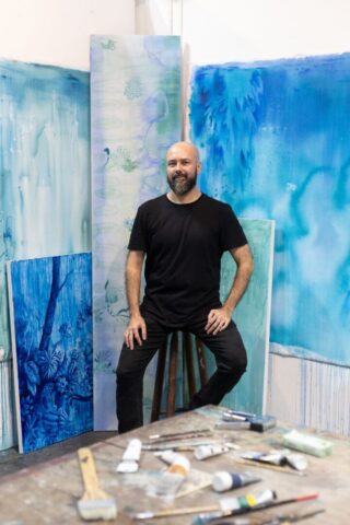 PedroVarela O artista Pedro Varela posa em seu ateliê diante de pinturas que integram a exposição "Vertido", em cartaz na Galeria Murilo Castro, em Belo Horizonte