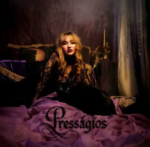 Amanda Birchal aparece em ensaio para o álbum “Presságios”, acompanhada de um gato preto em cenário de estética mística