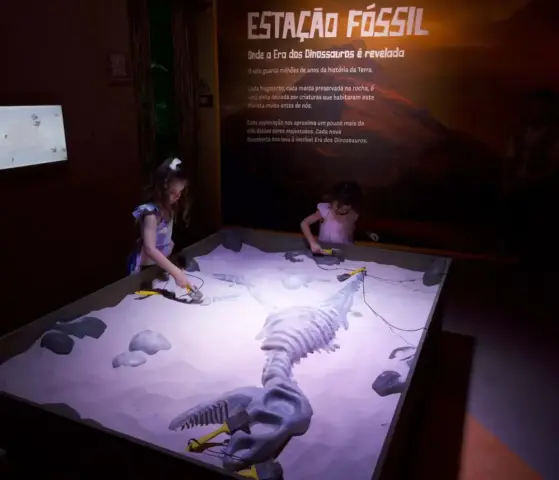 Crianças participam de atividade interativa na Estação Fóssil da exposição “A Era dos Dinossauros”, no Minas Shopping, em Belo Horizonte