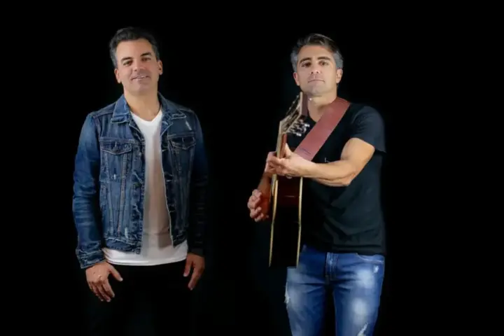 Dupla sertaneja Fred & Cris posa para foto de divulgação; um dos integrantes segura um violão