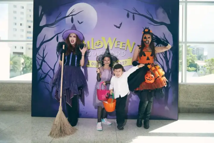 Crianças fantasiadas de Halloween posam ao lado de personagens caracterizados como bruxas em cenário temático no Boulevard Shopping BH
